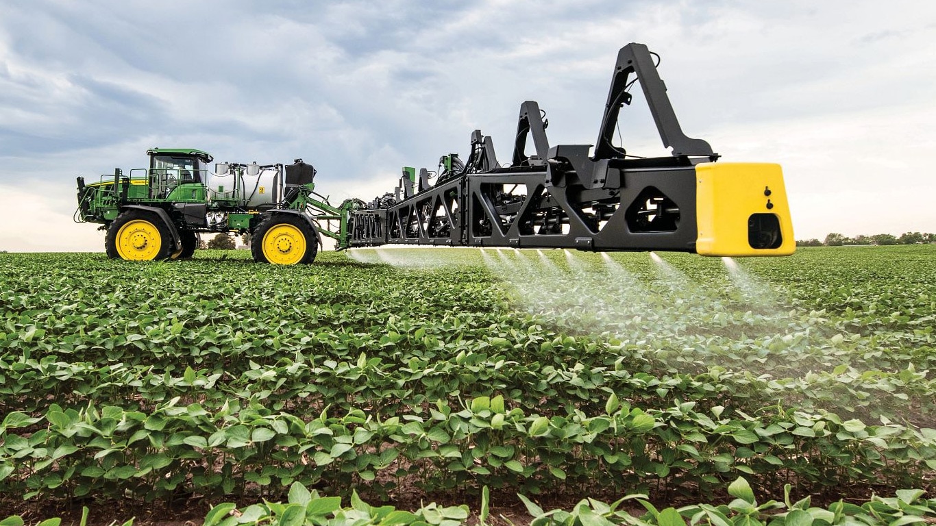 Skats uz John Deere smidzinātāja strēli tuvplānā atklātā laukā.