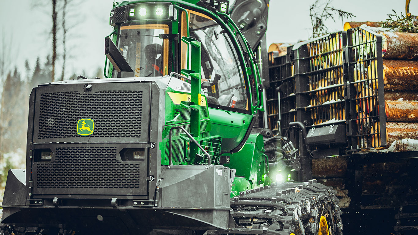 John Deere pievedējtraktors mežā