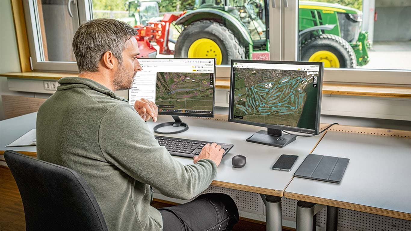 Golfa laukumu zālienu apsaimniekotājs savā datorā apskata golfa laukumu kartes.