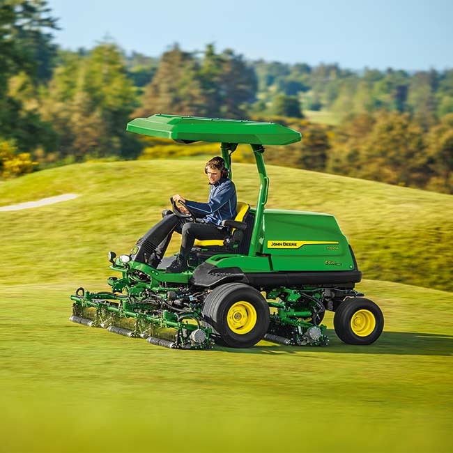 Golfa laukumu zālienu apsaimniekotājs strādā paklājzāliena zonā ar John Deere fērveja pļāvēju