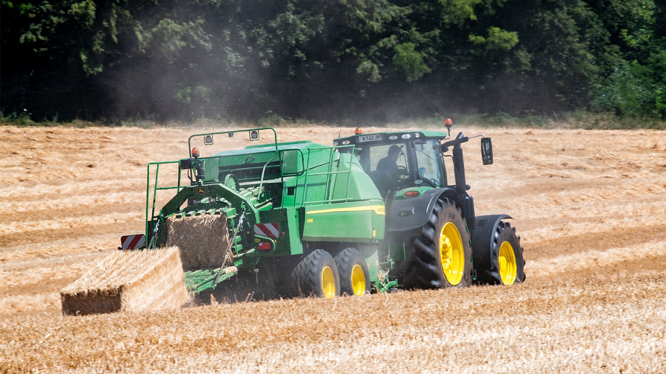 John Deere L634 lielo kvadrātveida ķīpu prese ar 6R traktoru salmu novākšanā