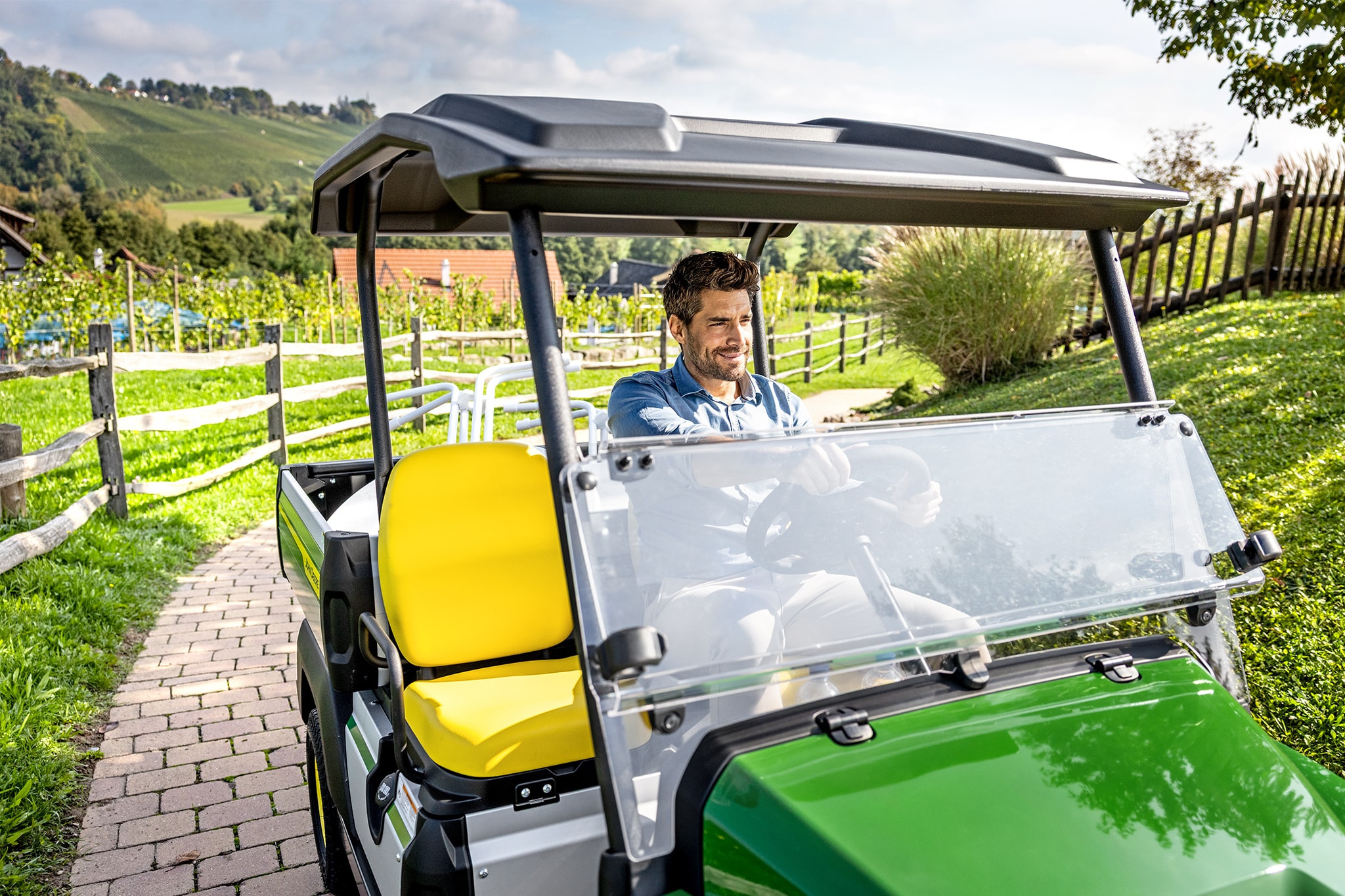 John Deere Gator GS salona tuvplāns ar dzelteniem sēdekļiem un stūres ratu John Deere Gator GS salona tuvplāns ar dzelteniem sēdekļiem un stūres ratu