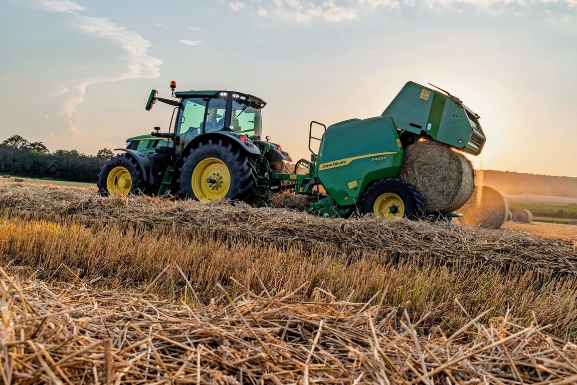 John Deere F442M presi velk John Deere 6M traktors, izstumjot salmu rulli