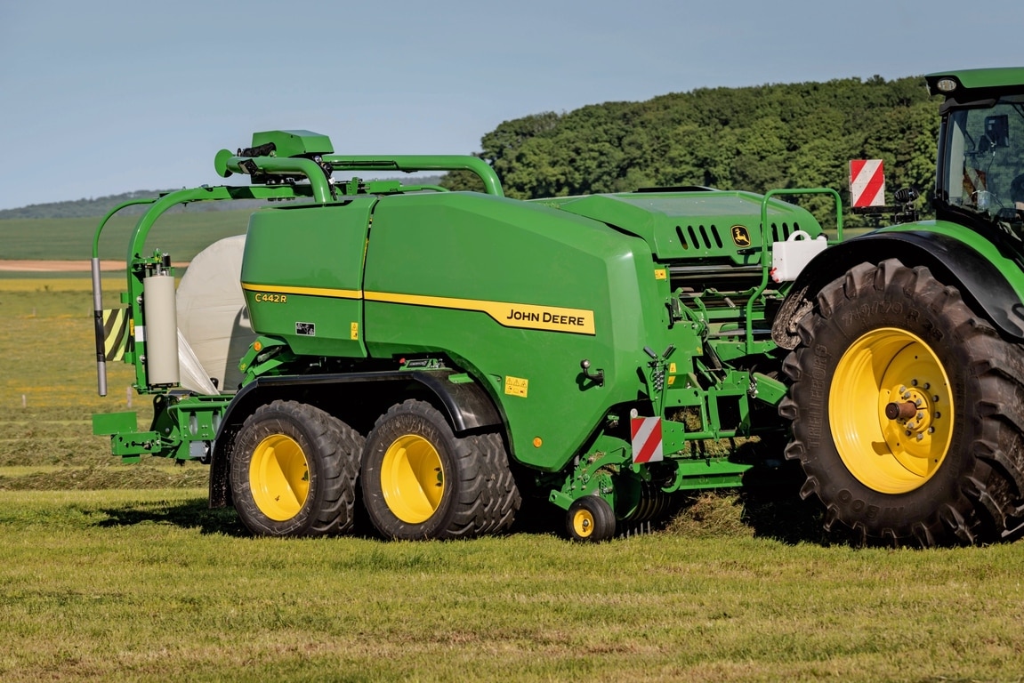 John Deere C442R ietīšanas ruļļu prese veido liela blīvuma skābbarības ruļļus