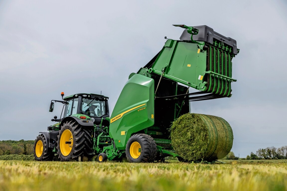 John Deere V462M presi velk John Deere 6M traktors, izstumjot zāles rulli