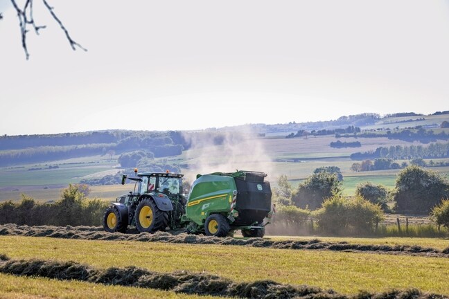 John Deere V462R, ko velk John Deere 6R 185 traktors, presē sienu